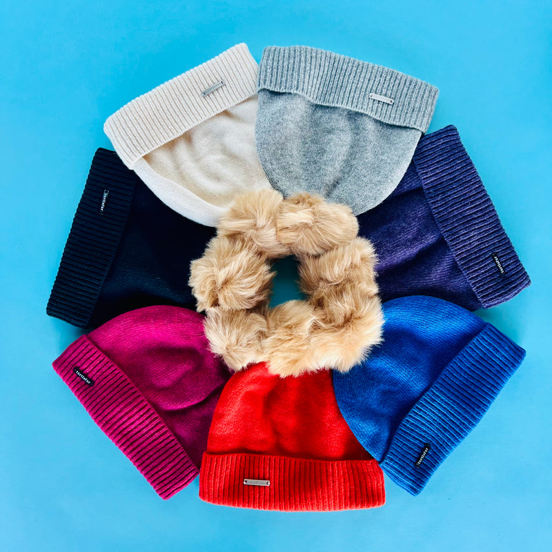 A flat lay of hats in different colors forming a circle